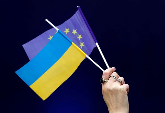 A woman holds Ukrainian and European Union flags during a policy debate of Ukraine's President and presidential candidate Petro Poroshenko with his rival, comedian Volodymyr Zelenskiy, at the National Sports Complex Olimpiyskiy stadium in Kiev, Ukraine April 19, 2019